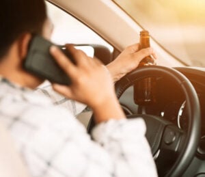 man driving with open container of alcohol